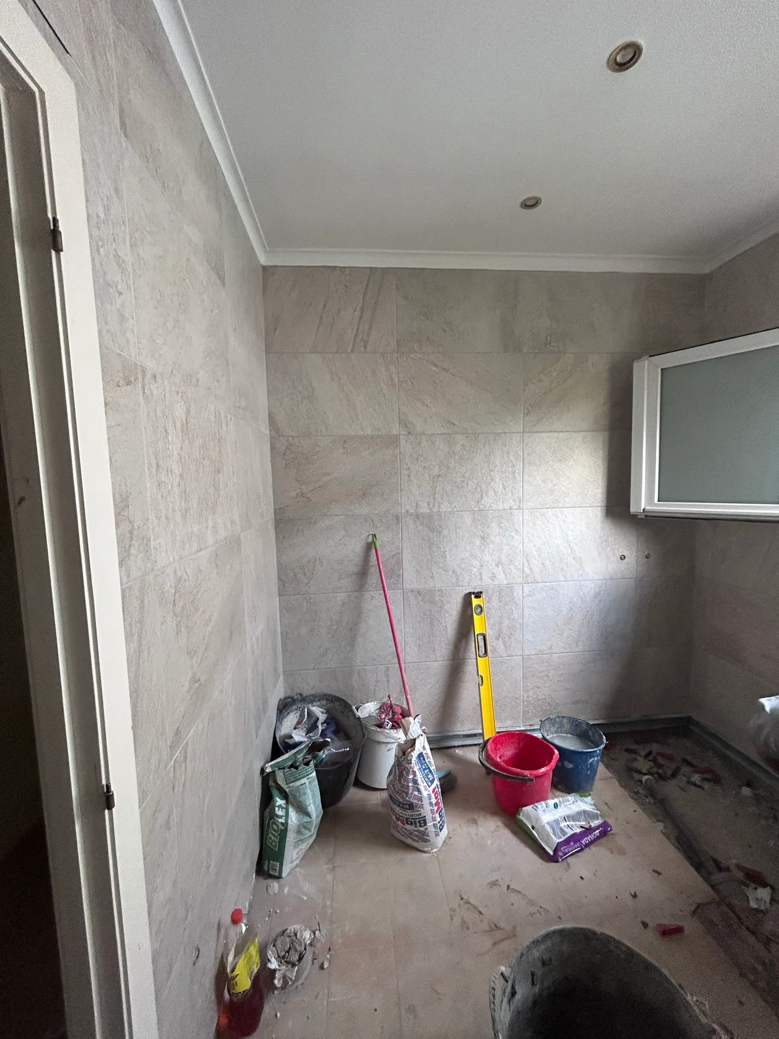 El baño de Banyoles durante el alicatado, con el porcelánico en colocación
